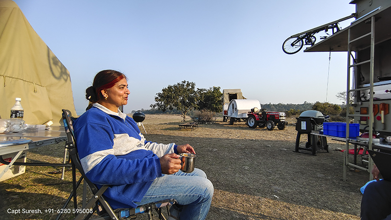 single woman enjoying curated holidays offbeat in caravan as soft adventure safe for women and solo girls campervan in himachal around pong dam india. 