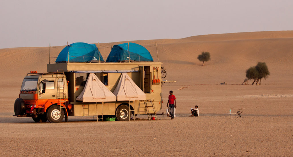 caravan with features of motorhome campervan deployed on sand dunes around jaisalmer for offbeat experiential nomadic camp corona safe holiday.