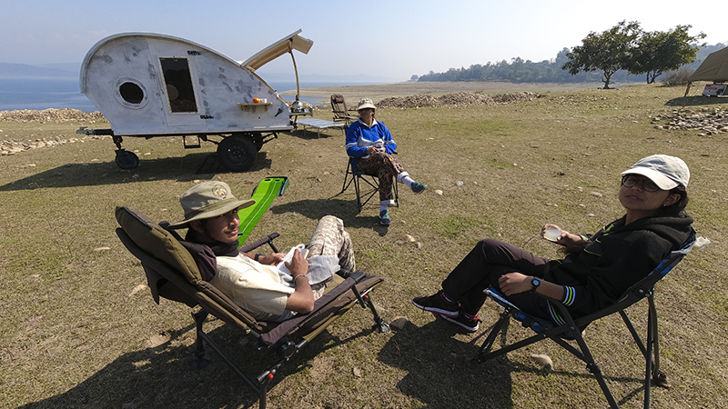 family enjoying workation and staycation at motorhome camping trailers himachal for offbeat locations with nature camp corona safe social distancing at Pong Dam.
