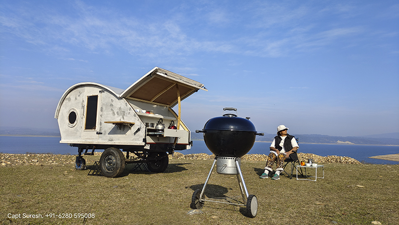 single woman enjoying offbeat holidays with caravan camping and weber barbecue grill around pong dam which is safe from corona covid himachal.