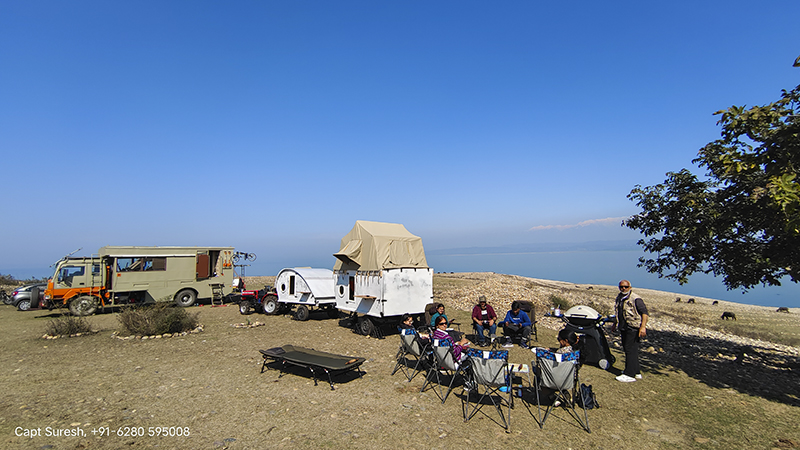 family enjoying in lakeside camp with caravan motorhome campervan in himachal for offbeat outdoor nomadic camp corona safe.